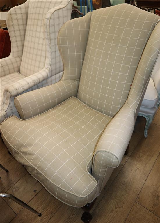 A George III style upholstered wing armchair on claw feet